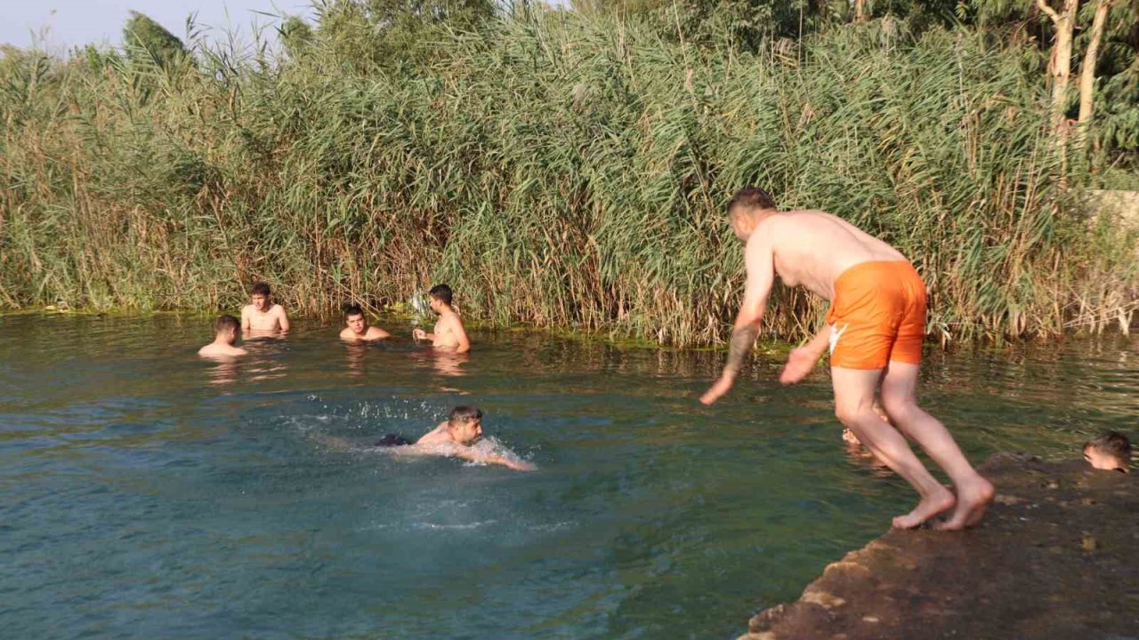 Adana’da gençler bunaltan sıcakta gölette serinledi