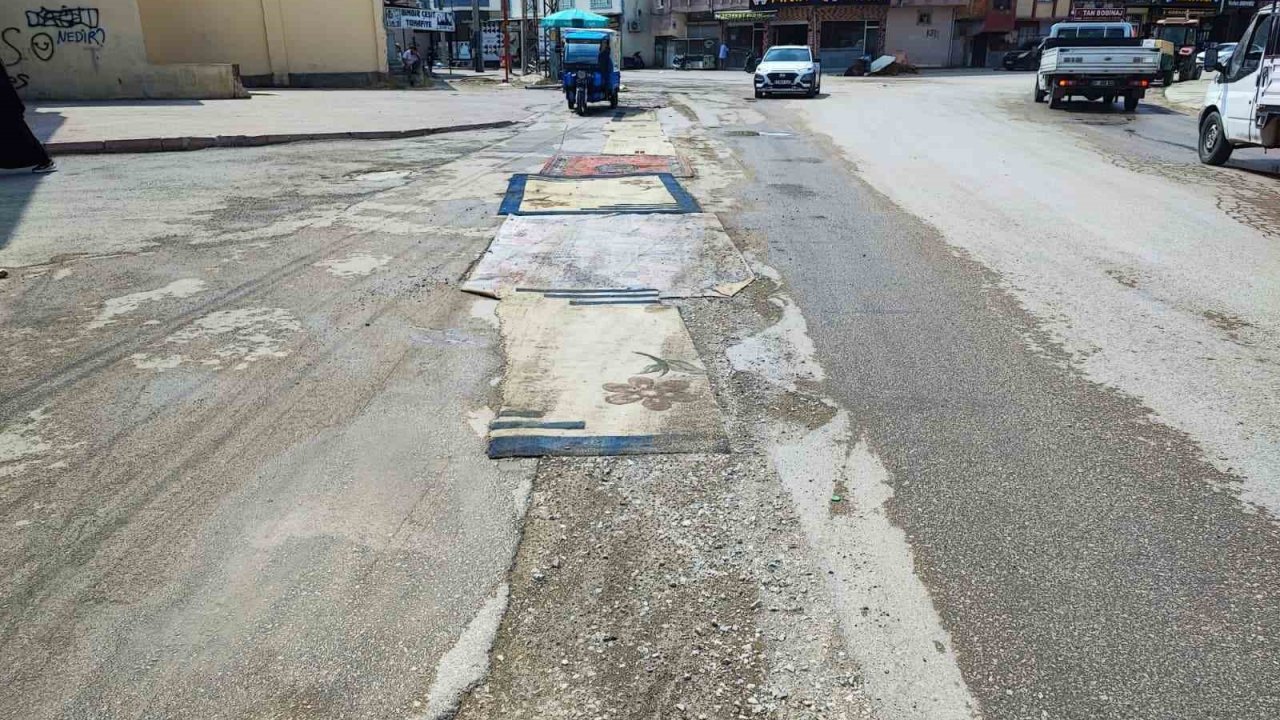 Adana’da belediyenin yapmadığı yola esnaftan ilginç çözüm: Yola asflat yerine halı serildi