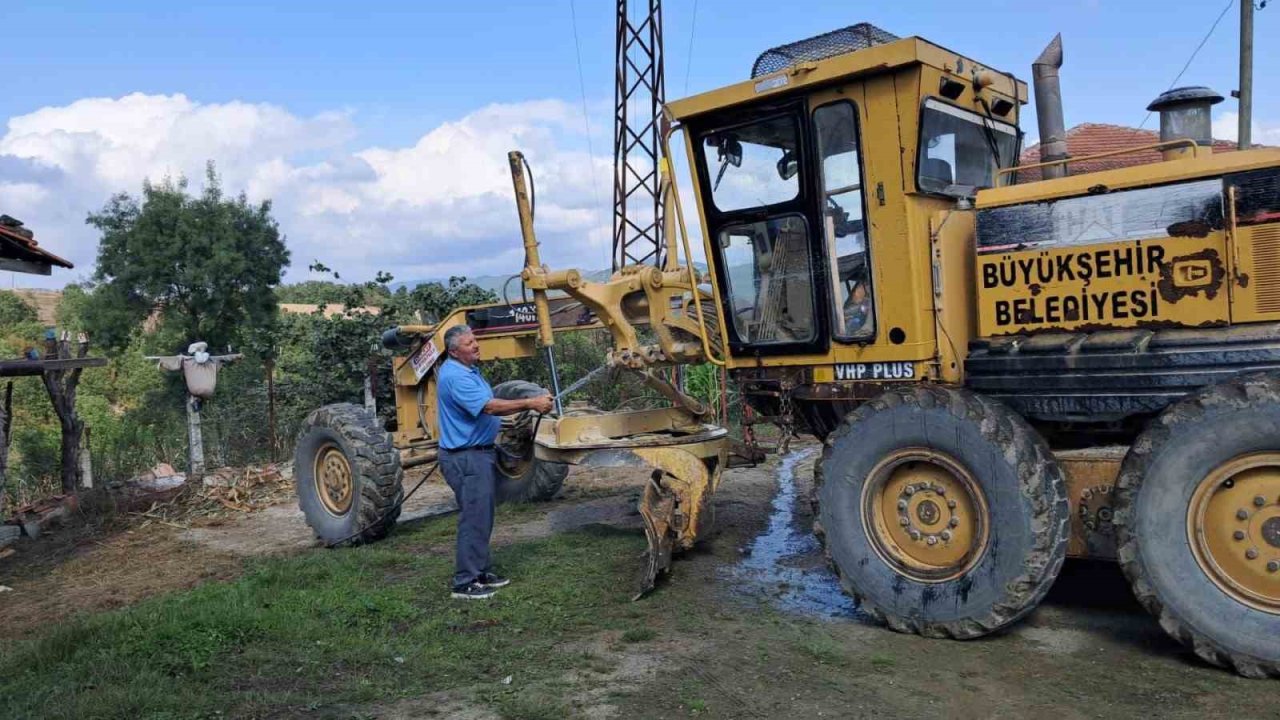 Muhtar, yol çalışması yapan iş makinesini kendi elleriyle yıkadı