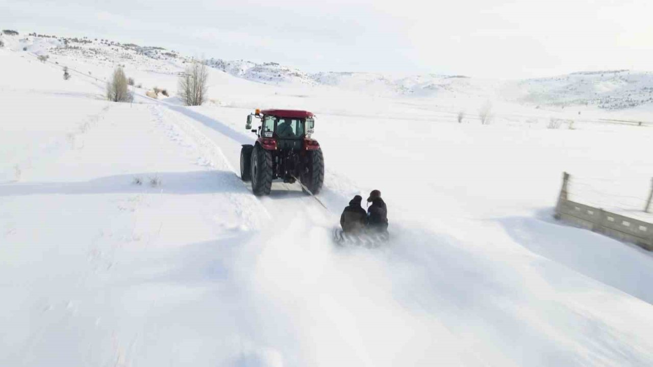 Kar yağışını fırsata çevirdiler, traktörün arkasında kayarak eğlendiler