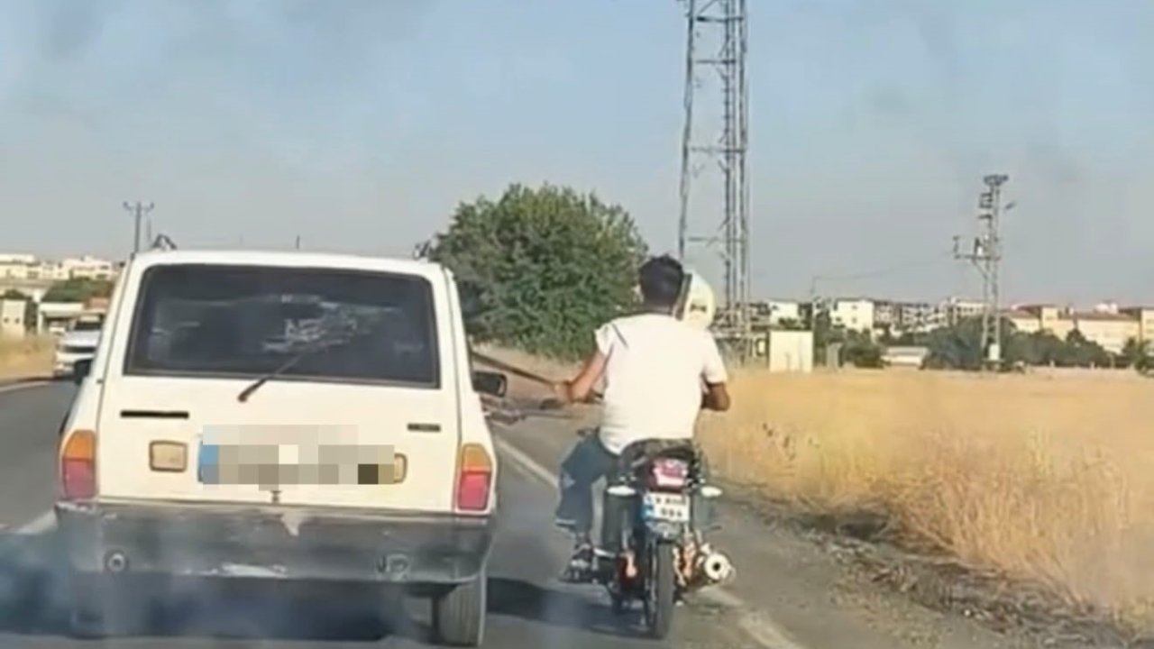 Otoyolda tehlikeli yolculuk: Motosiklet, otomobil kemerine tutunarak ilerledi