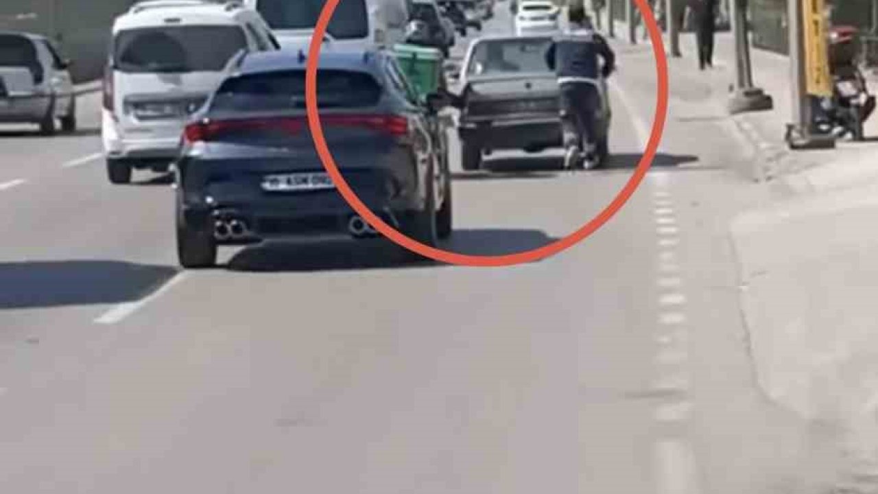 Bursa’da motokuryeden arızalanan otomobili itmek için ilginç yöntem