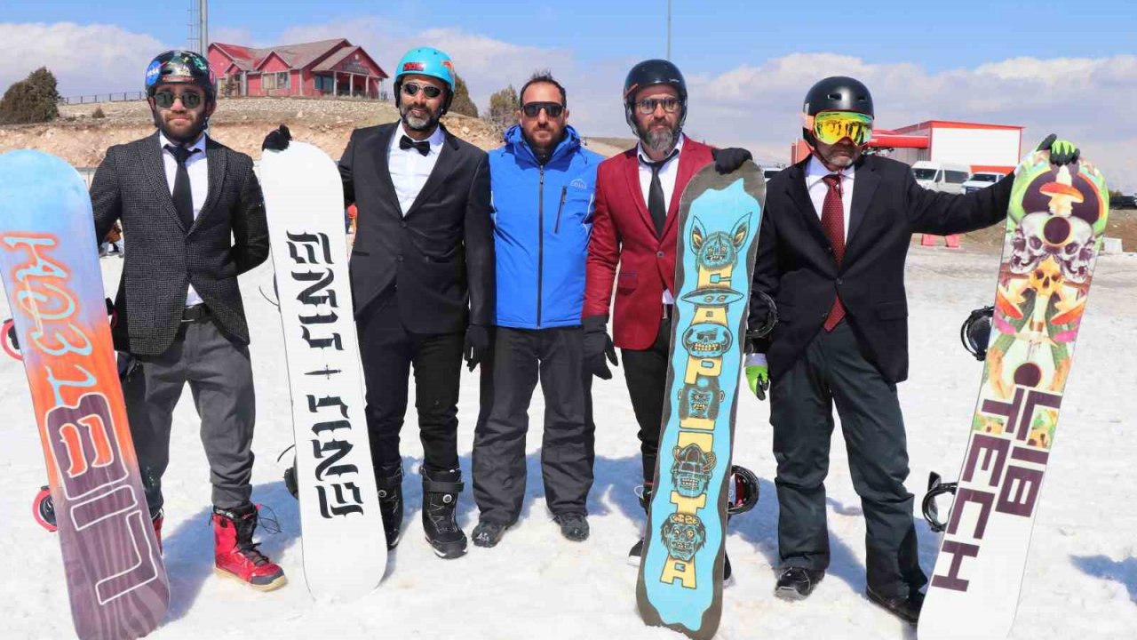 Kayak sezonunu takım elbiseyle snowboard yaparak uğurladılar