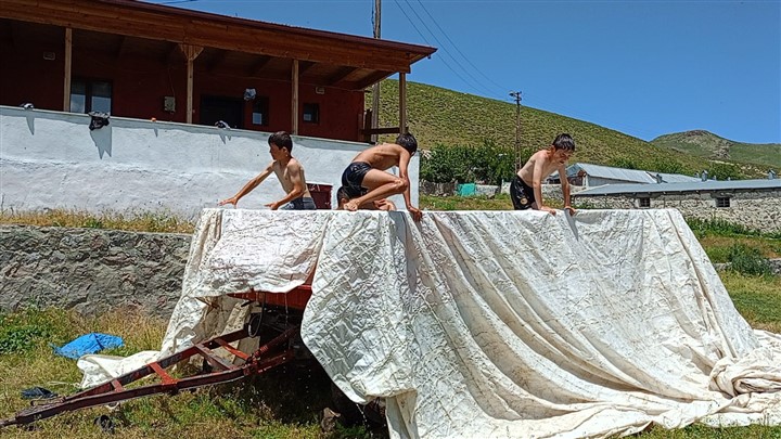 Kars'ta çocuklar serinlemek için traktör römorkunu havuz yaptı