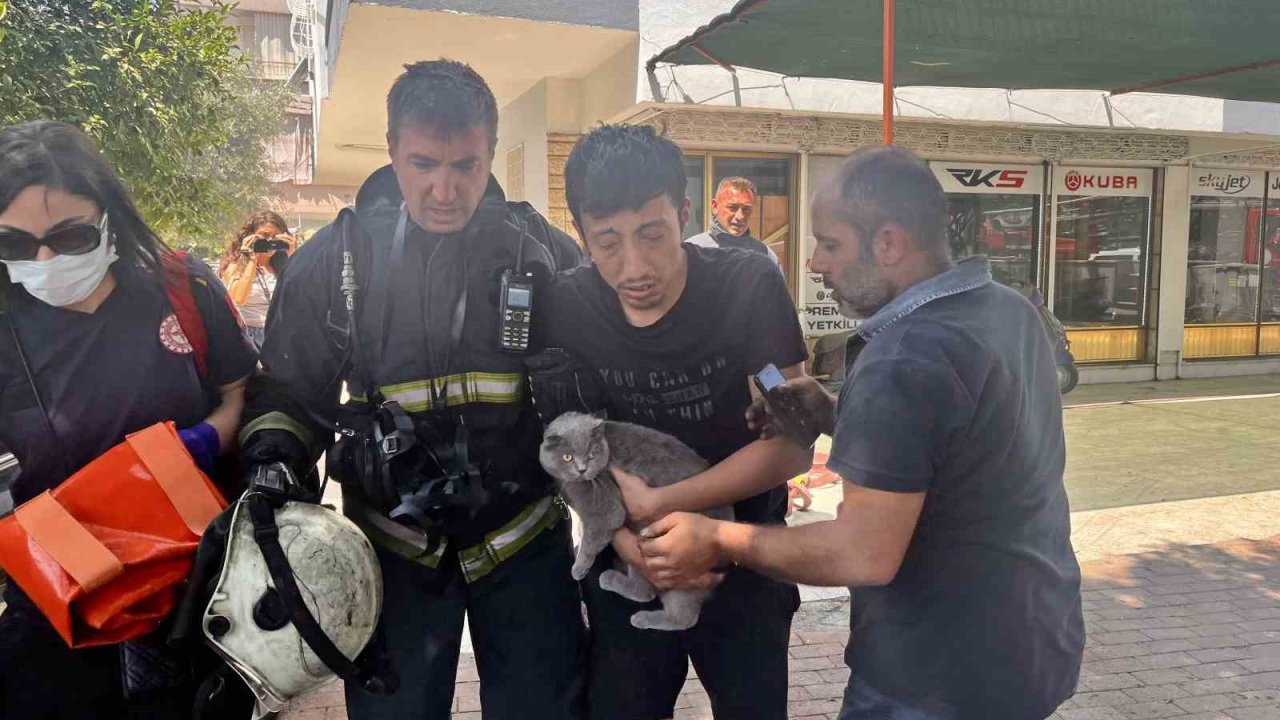 Alevlerin sardığı evde balkona sığındı kedisini elinden bırakmadı