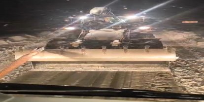 Karlı yolda mahsur kalan tır, iş makinesiyle kurtarıldı