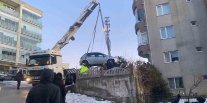 Buzlanan yolda kayan otomobil apartmanın bahçesine düştü