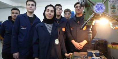 Kadın öğretmen torna tezgahında öğrencilerine üretimi öğretiyor