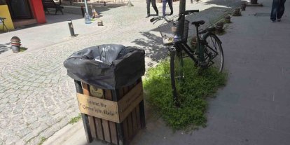 Çöp kutusunun hemen yanındaki bisikletin sepeti atıklarla doldu