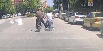 Bisiklet ile motosikleti ayağı ile iterek ilerletti