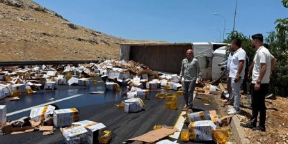 Devrilen tırdaki yağ bidonları yola savruldu