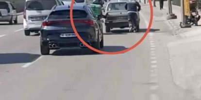 Bursa’da motokuryeden arızalanan otomobili itmek için ilginç yöntem