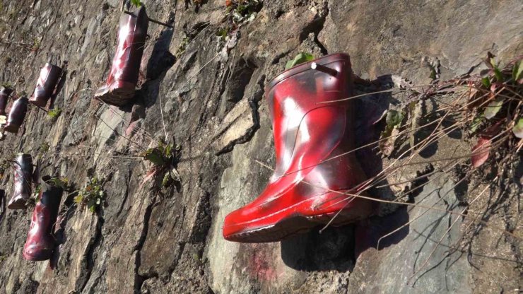 Taş duvarı saksı olarak kullandığı çizmelerle renklendirdi