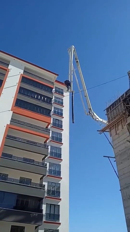 Beton pompasının üzerinde metrelerce yüksekliğe çıkan işçi, adeta ölüme meydan okudu