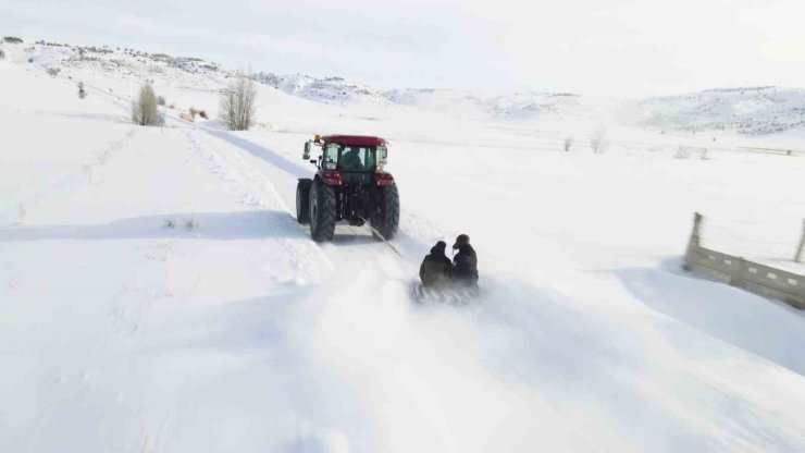 Kar yağışını fırsata çevirdiler, traktörün arkasında kayarak eğlendiler