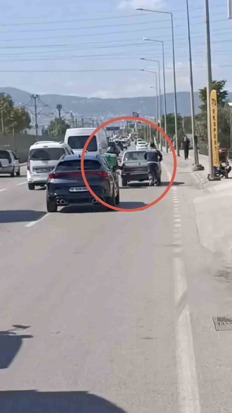 Bursa’da motokuryeden arızalanan otomobili itmek için ilginç yöntem